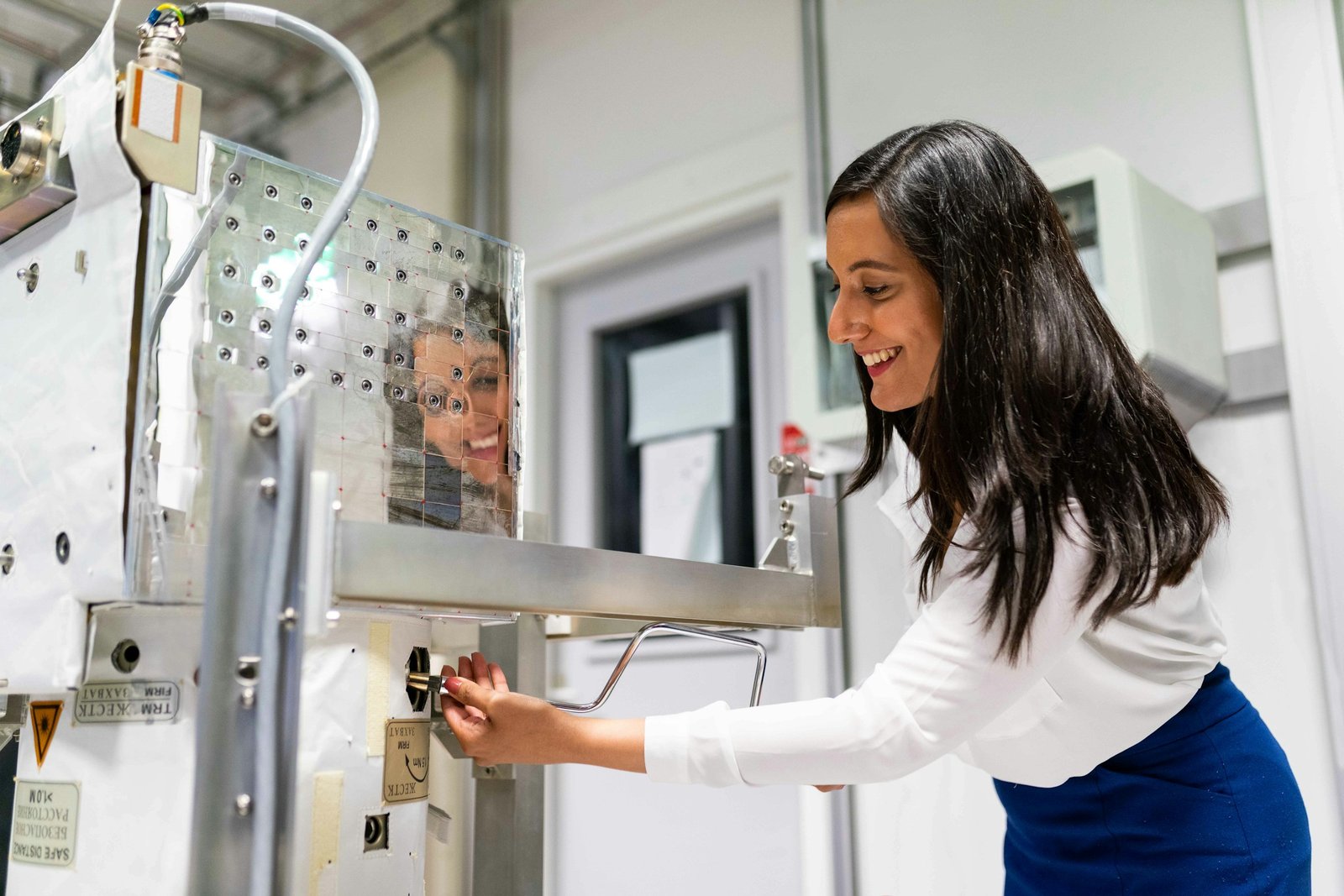 Smiling engineer adjusting a machine