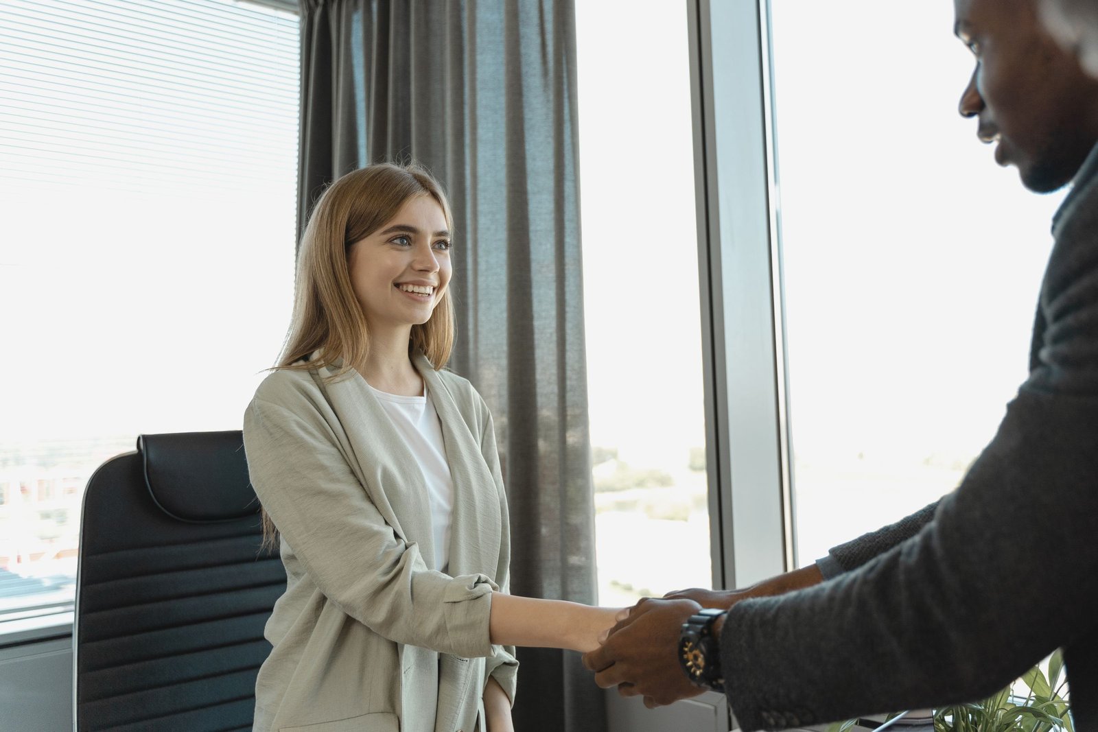 Smiling candidate greeting her interviewer with a handshake
