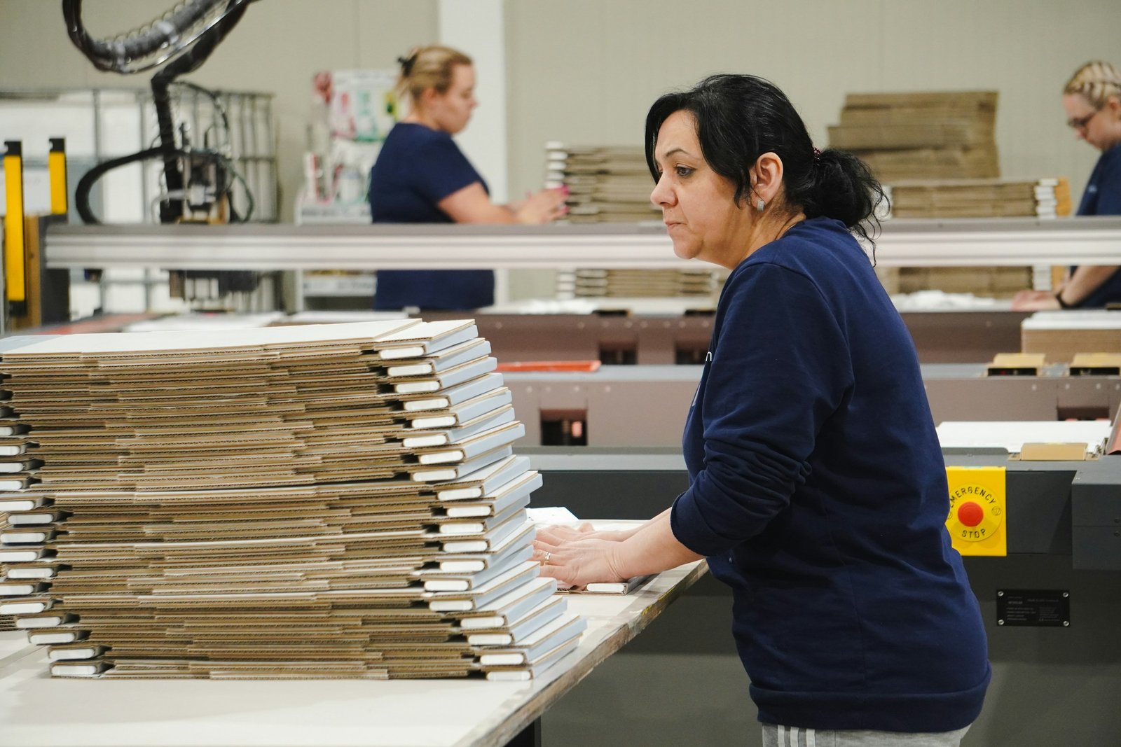 Worker at a production line for cardboard packaging