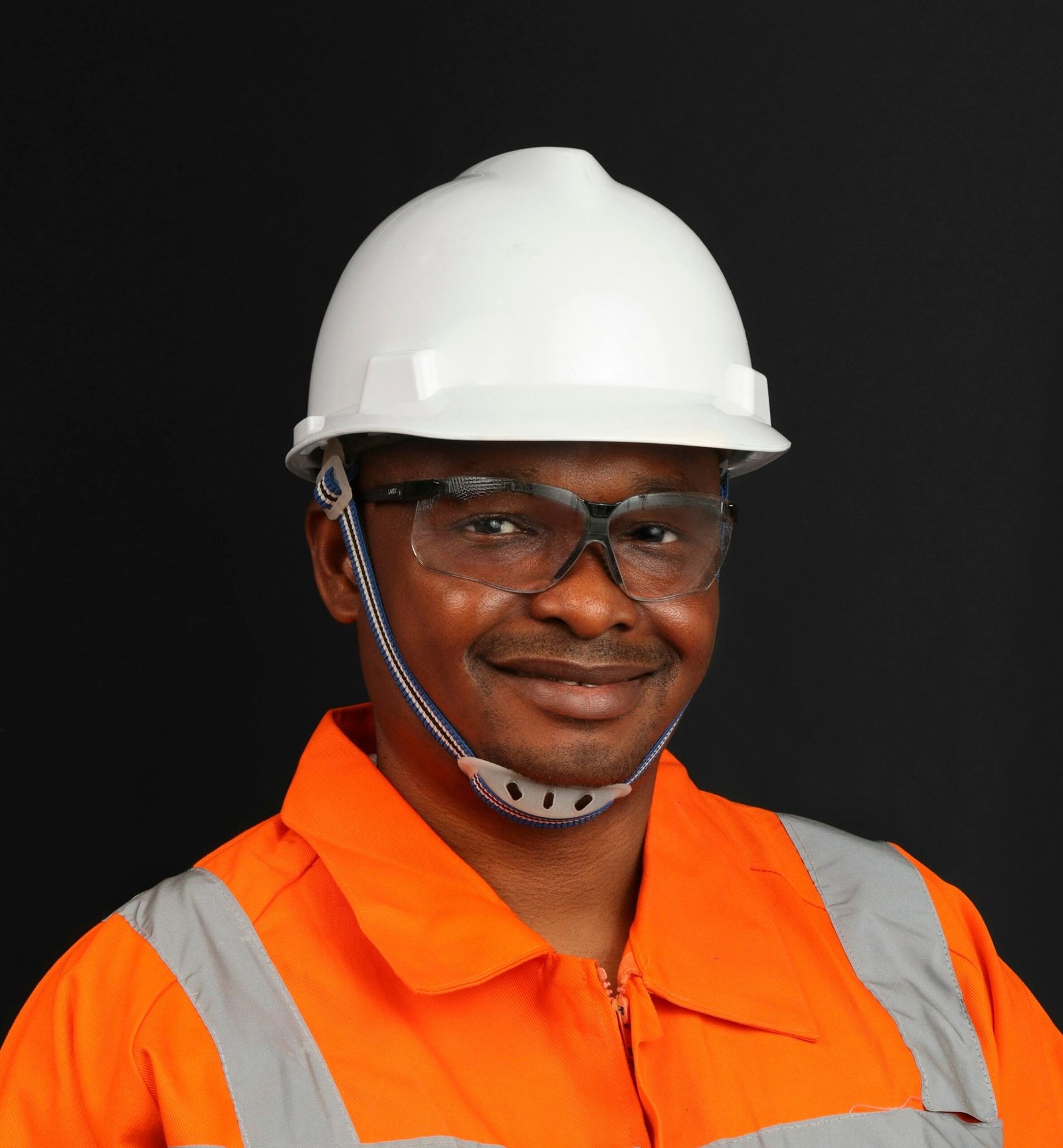 Smiling worker with hard hat, safety glasses and high-visibility clothing